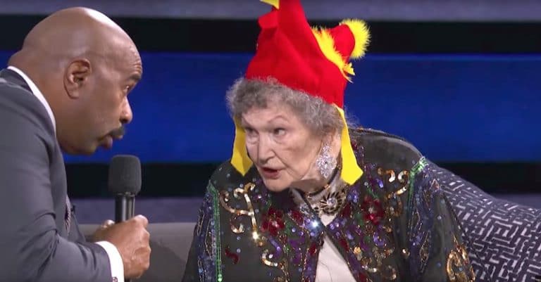 Bonnie Swalwell Eilert demonstrating her animal calls to Steve Harvey while wearing a chicken hat