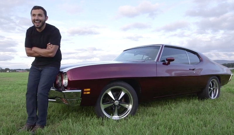 Carlos from Carspotting leaning on a classic muscle car