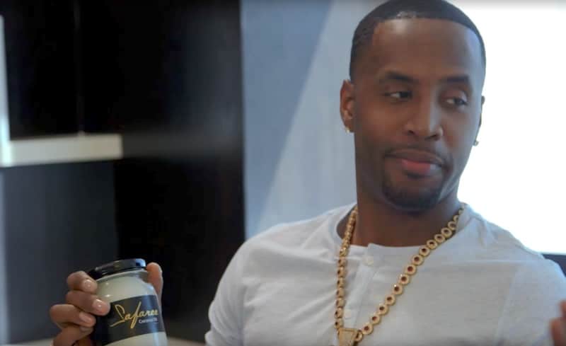 Safaree holding a tub of own-brand coconut oil at a fertility clinic
