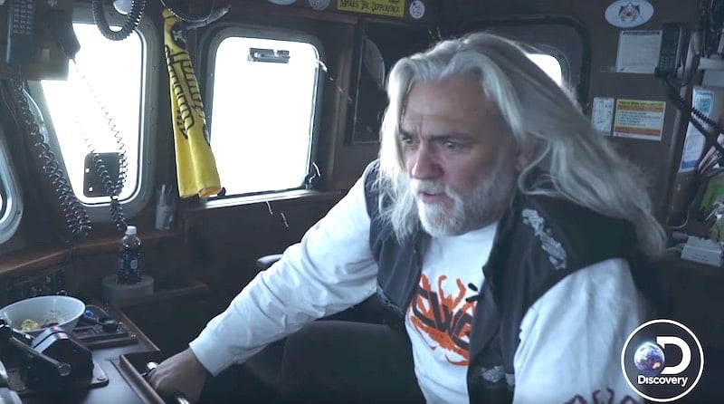 Captain 'Wild Bill' Wichrowski holding on to a metal bar in a cockpit of the Summer Bay on Deadliest Catch