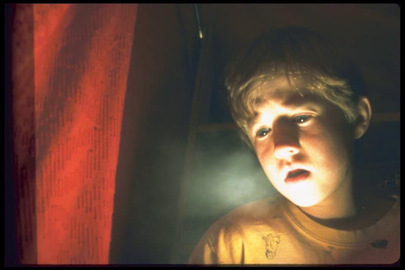 Haley Joel Osment as Cole Sear looks at a glowing light in The Sixth Sense