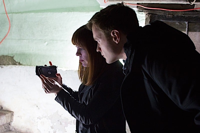 Adam Berry looks at the viewfinder of Amy Brunis handheld camera