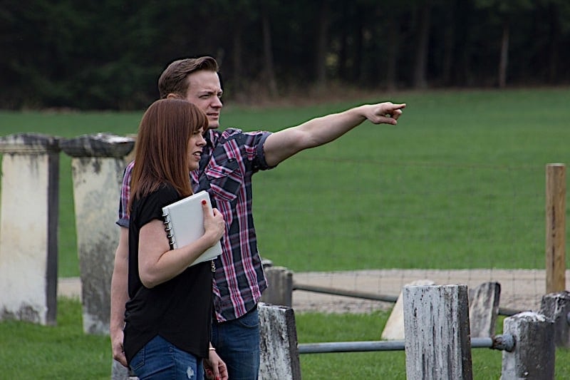 Adam Berry points out something to Amy Bruni in a cemetery.
