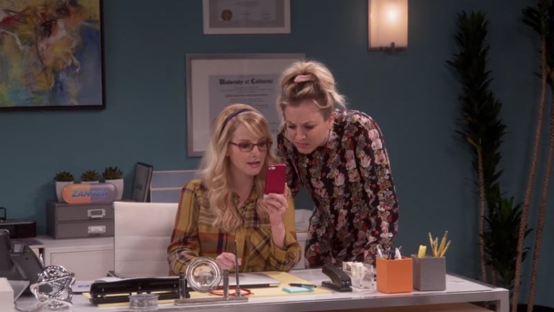 Penny and Bernadette looking at a photo on a cell phone on Big Bang Theory