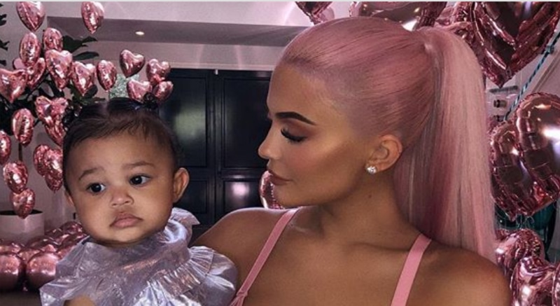 Kylie Jenner and her daughter Stormi Webster pose from inside their home in Calabasas