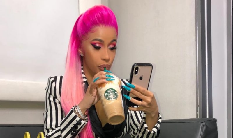 Cardi B sipping on Starbucks and checking her phone