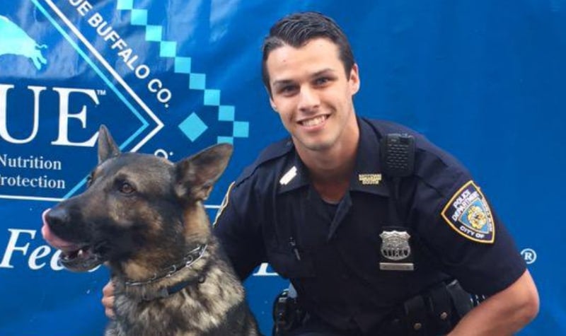 Brendan McLouglin with a police K9 while working