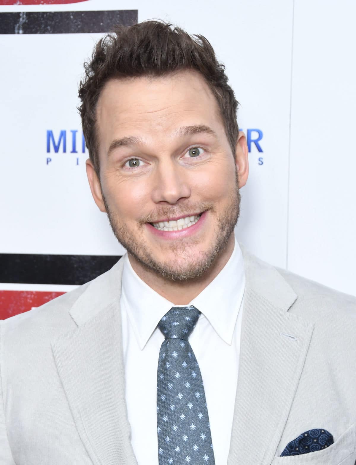 chris pratt jokes with photographers as he hunks out grey suit at