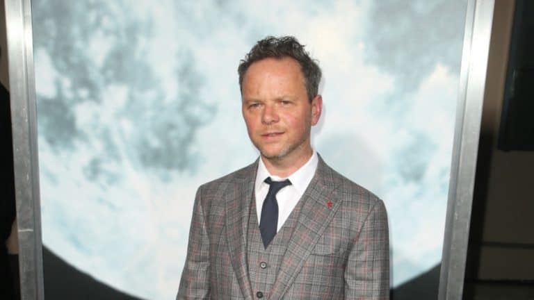 Noah Hawley posing in front of picture of the moon