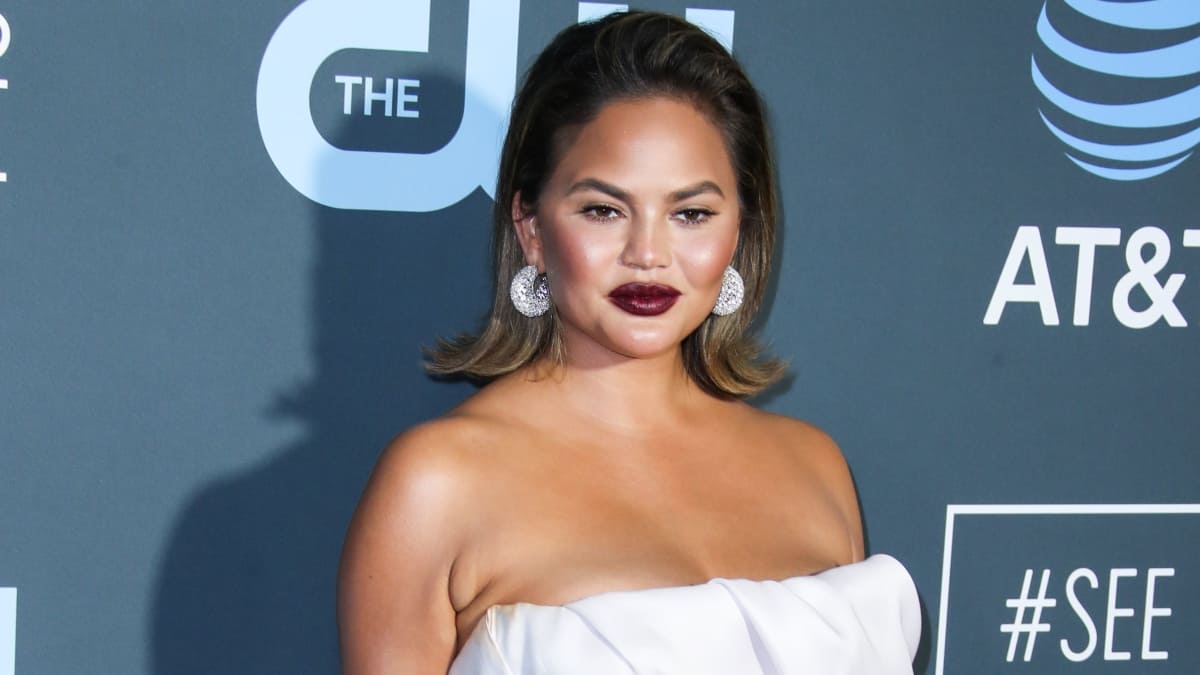 Model Chrissy Teigen wearing a Maison Yeya dress, Stuart Weitzman shoes, Jaipur Gems earrings, Yvan Tufenkjian rings and carrying a Jimmy Choo clutch arrives at the 24th Annual Critics' Choice Awards held at the Barker Hangar