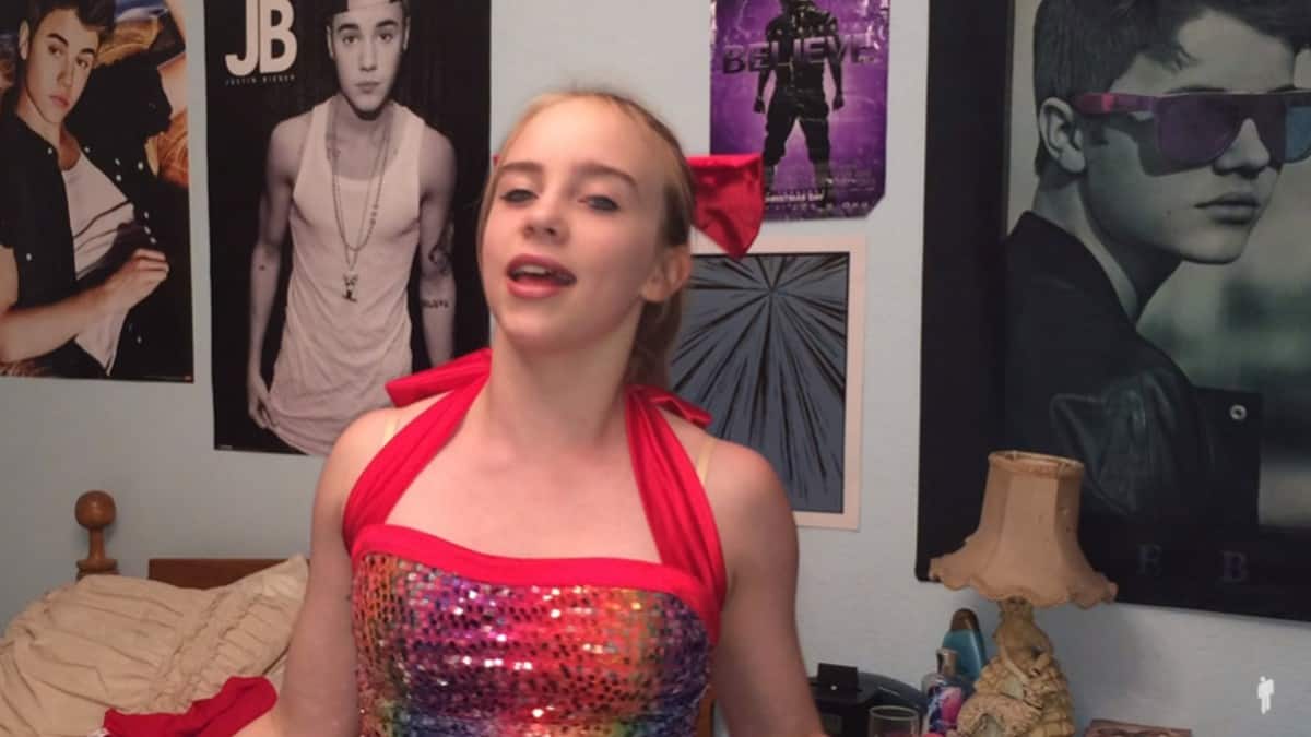 Billie Eilish in bedroom surrounded by Justin Bieber posters