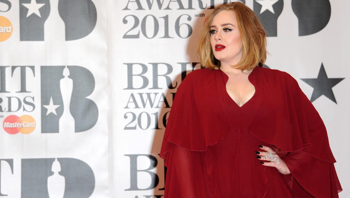 Adele poses in red gown at the 2016 Brit Awards