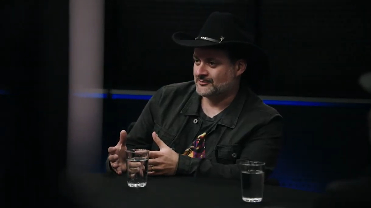 Director and writer Dave Filoni sits at a table