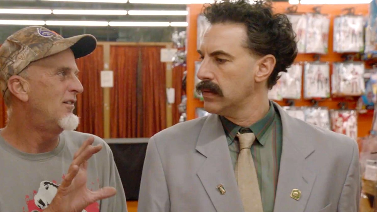 Sacha Baron Cohen as Borat talking to stranger.