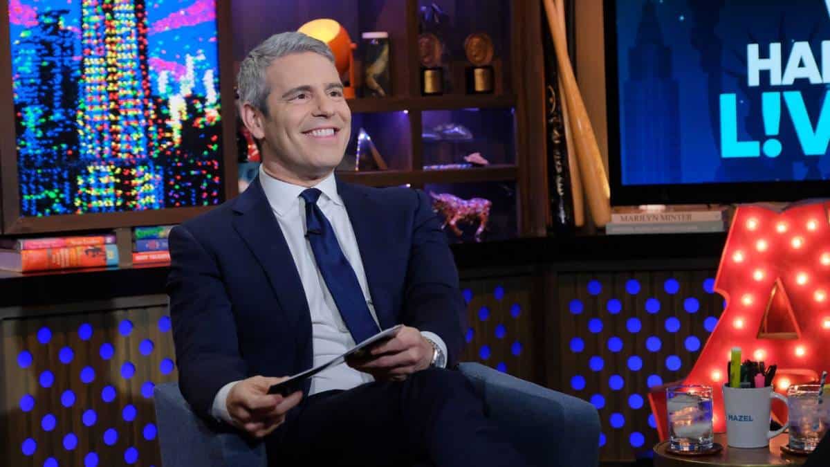 Andy Cohen sits in an armchair was he films WWHL.