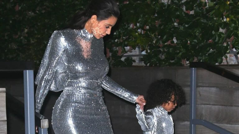 Kim Kardashian and daughter North West holding hands, walking down stairs