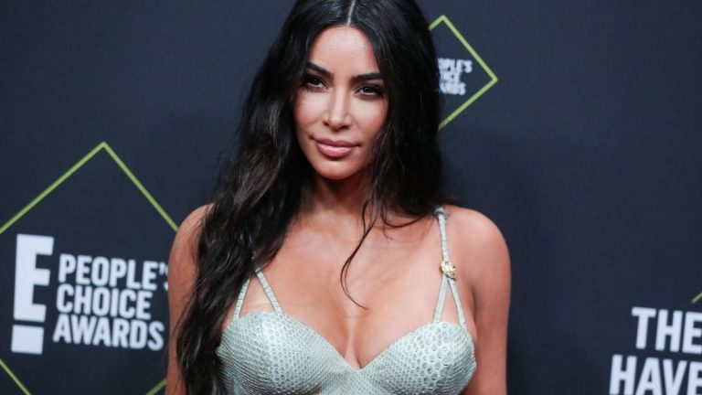 Kim Kardashian in a light green dress, posing at the People's Choice Awards.