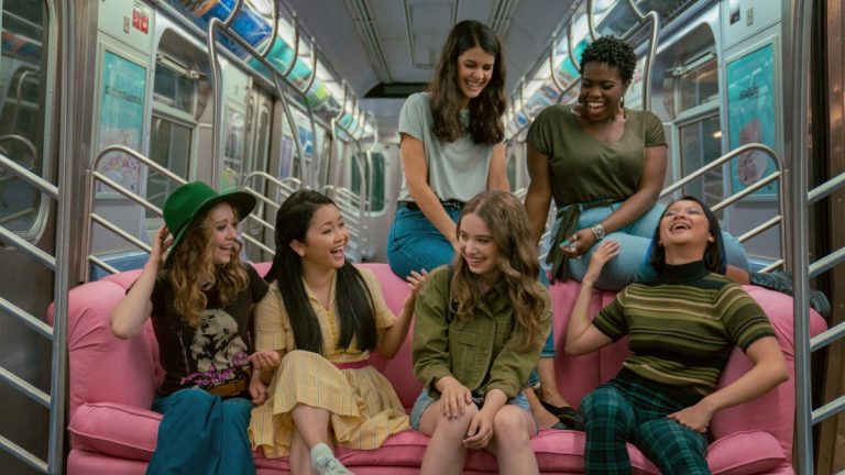 A picture from To All the Boys: Always and Forever of the characters sitting on a pink couch in the subway.