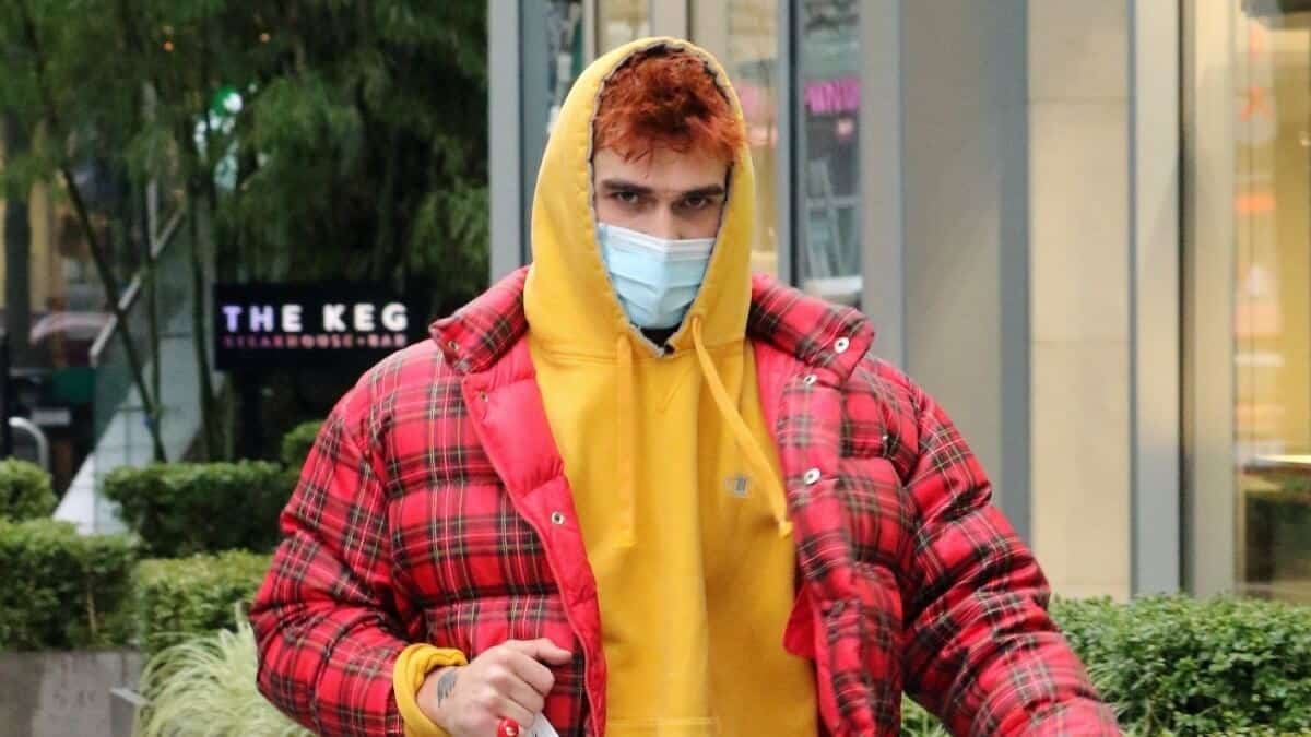 Image of KJ Apa carrying a grocery bag.