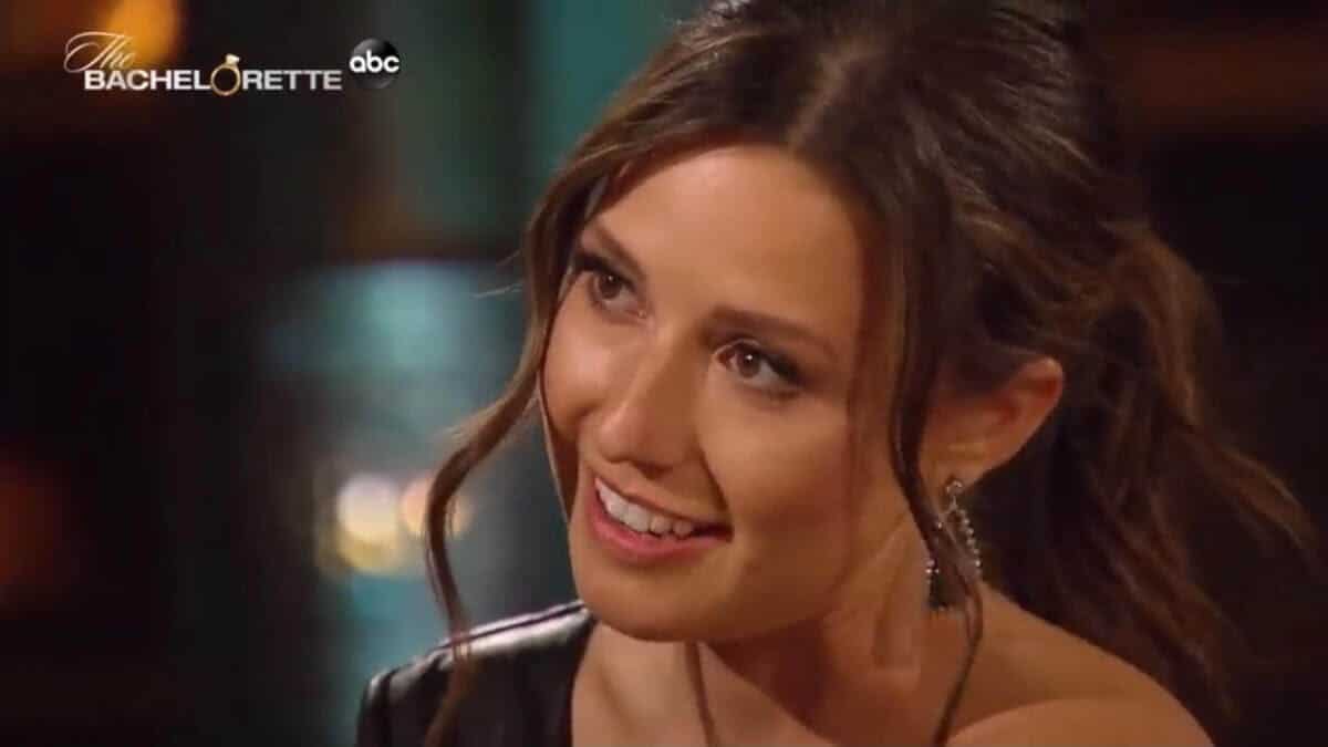 Katie Thurston smiles in drop earrings and evening wear