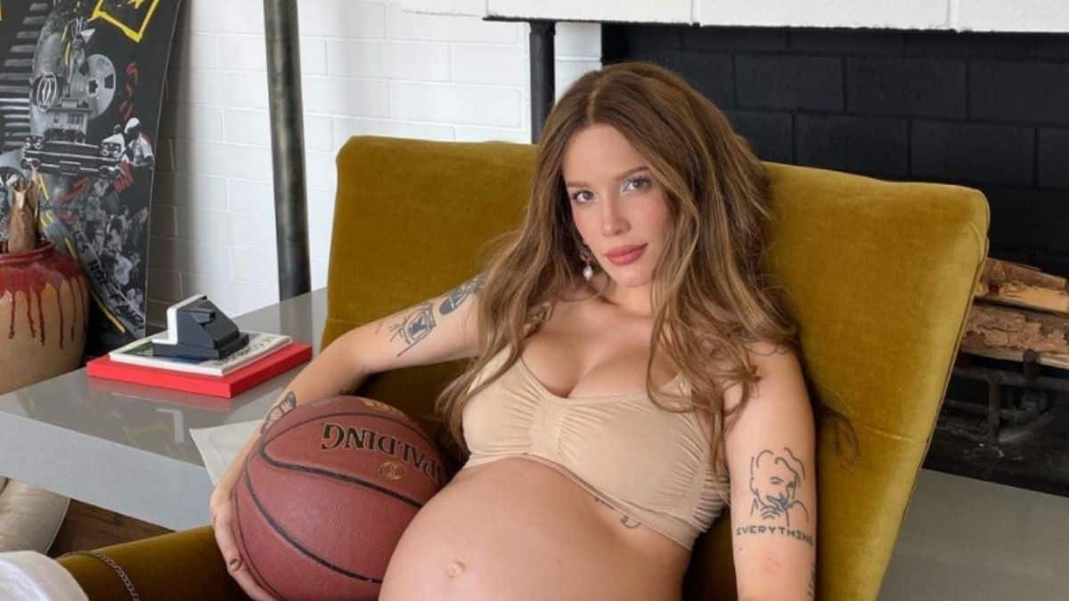 Image of Halsey holding a basketball next to her baby bump.