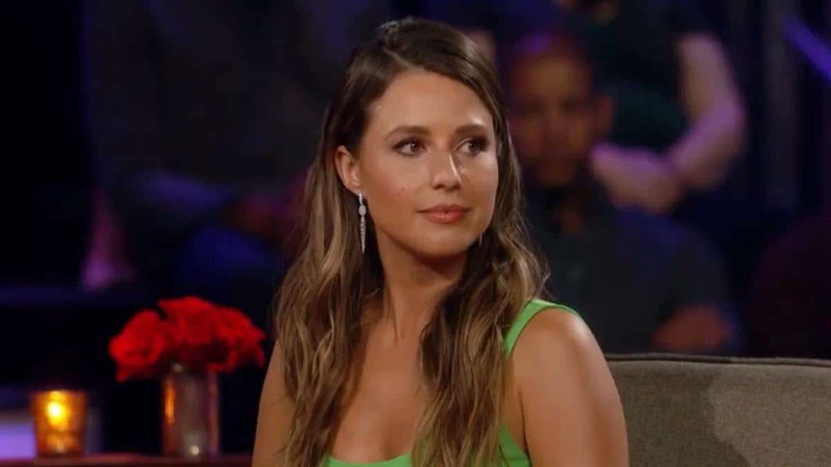 Katie Thurston wears a neon green dress while sitting on the couch