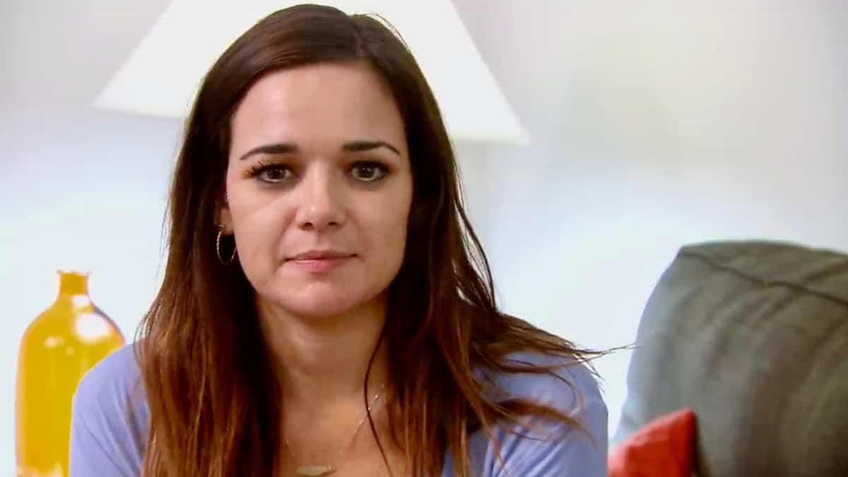 Virginia Coombs sits in her living room and stares in the camera