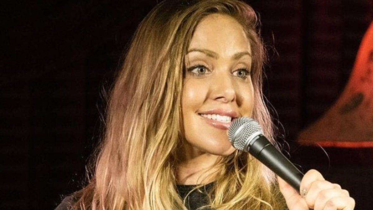 Kate Quigley holds a microphone