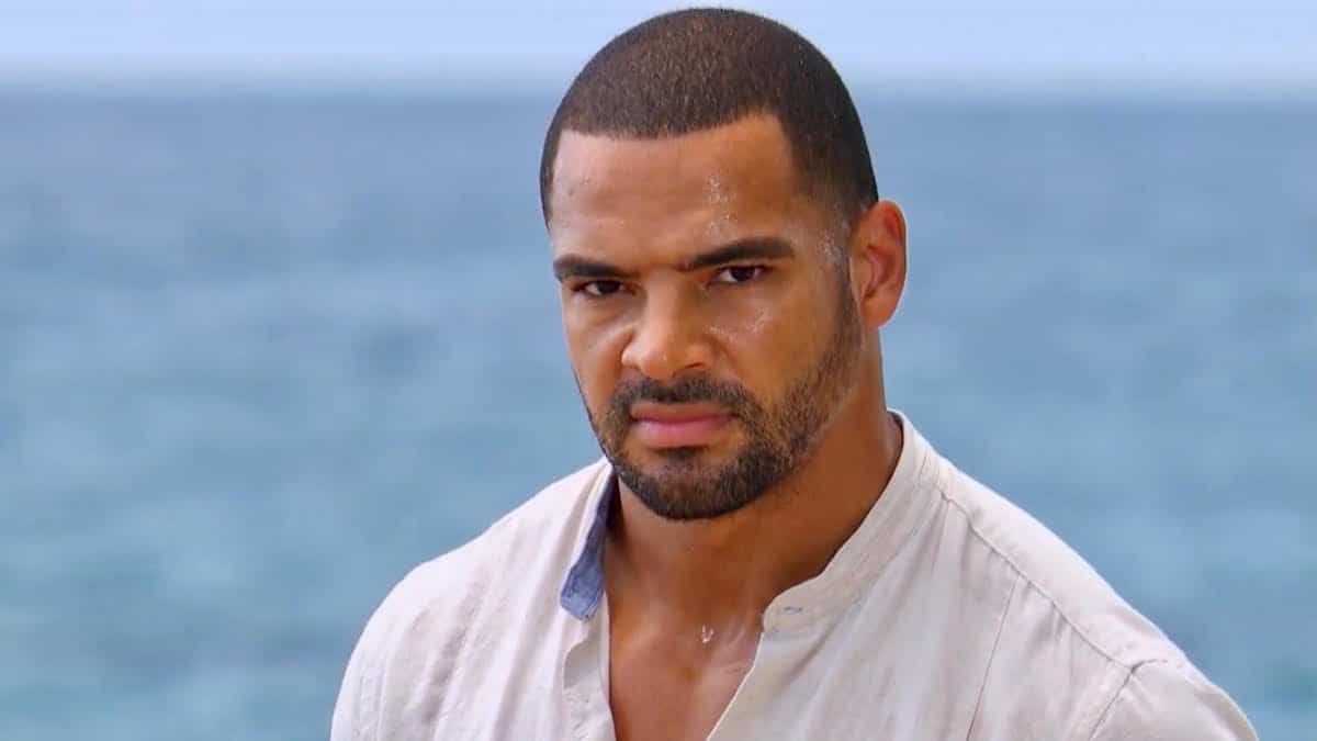 Clay Harbor stares at the camera by the ocean