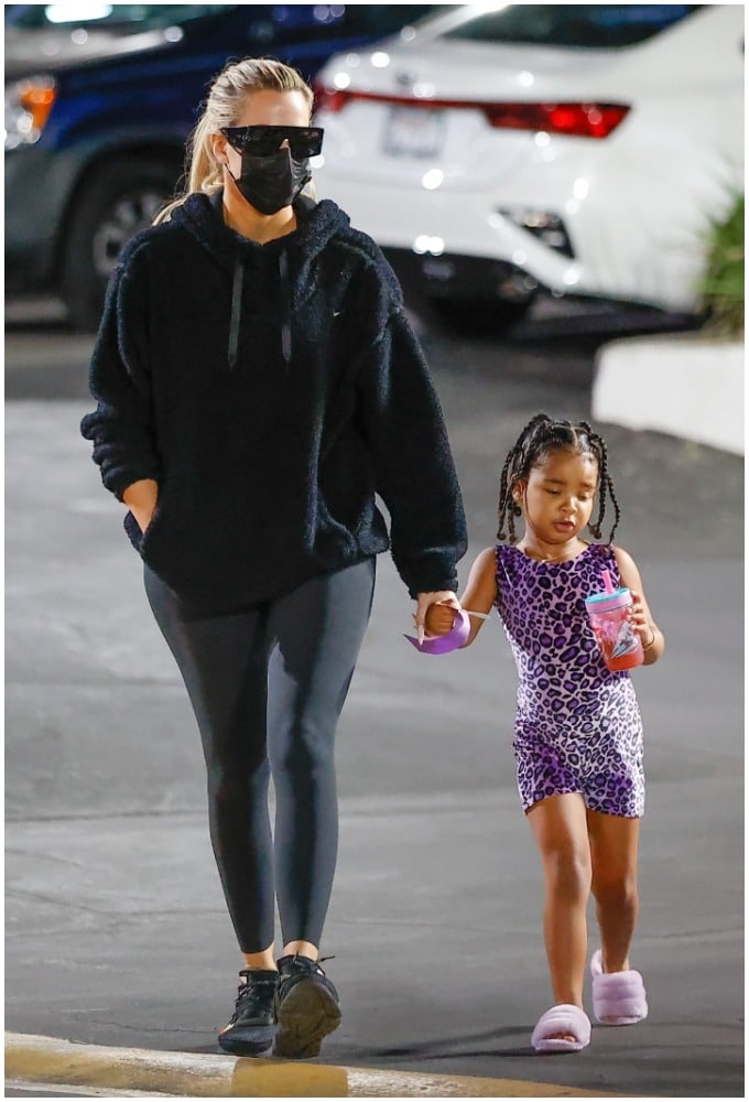 Khloe Kardashian and True Thompson walking and holding hands. 