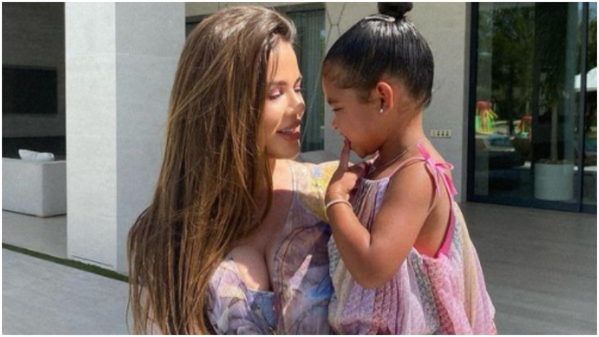 Khloé Kardashian holding her daughter, True Thompson, while smiling.