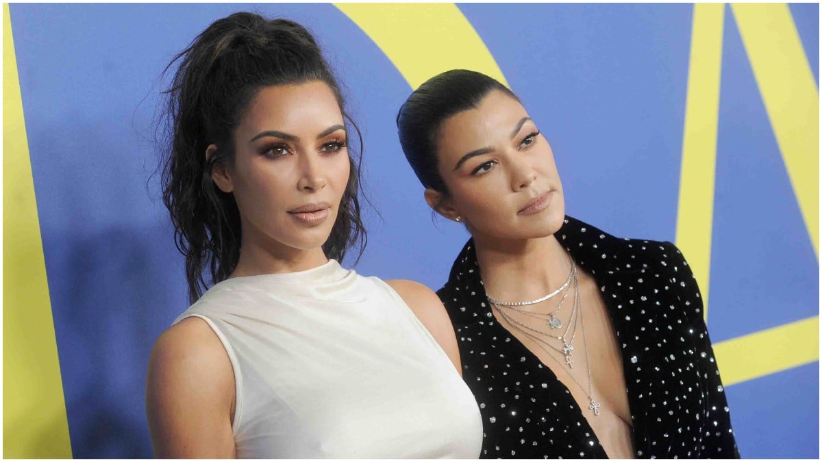 Kim Kardashian and Kourtney Kardashian posing on the red carpet.