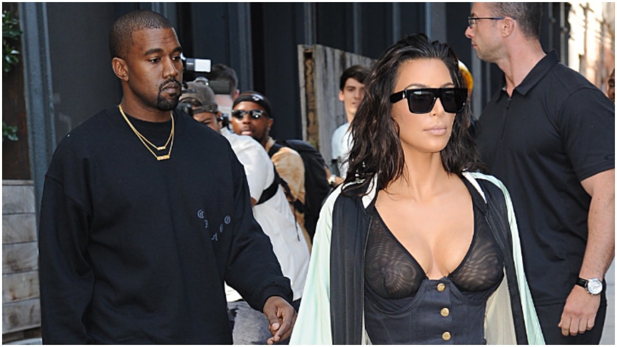 Kim Kardashian walking in front of Kanye West.