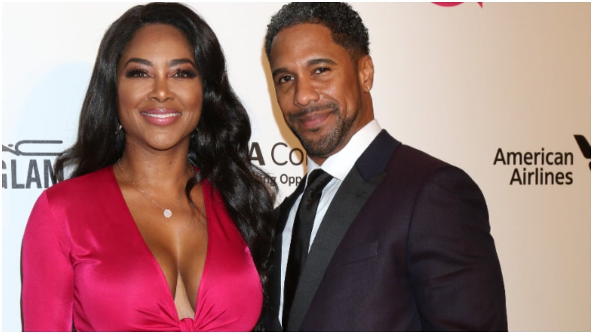 Kenya Moore and Marc Daly smiling and posing together on the red carpet.