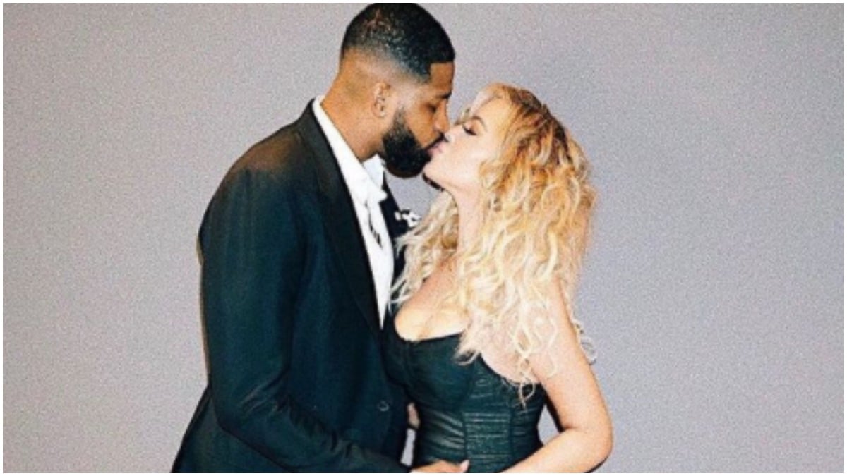 Tristan Thompson and Khloe Kardashian kissing while he holds her baby bump.
