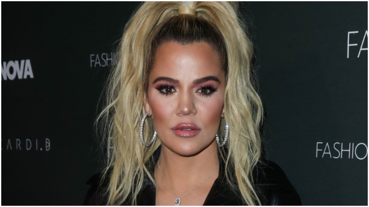 Khloe Kardashian wearing a high ponytail and a black shirt at an event.