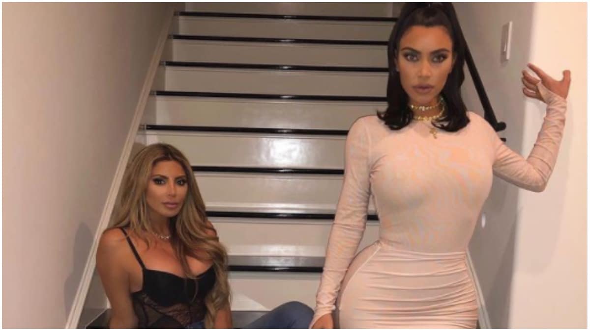 A screenshot of Larsa Pippen sitting on the stairs and Kim Kardashian standing in a white dress.