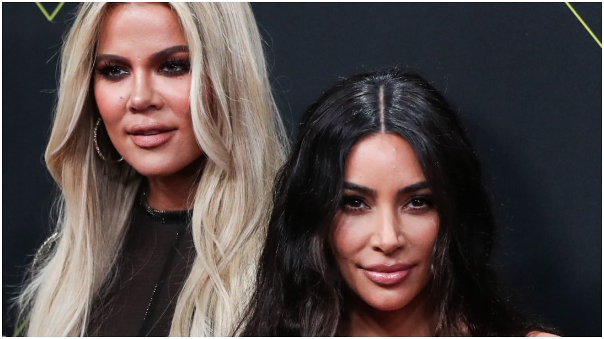 Khloe Kardashian and Kim Kardashian posing at an awards show.