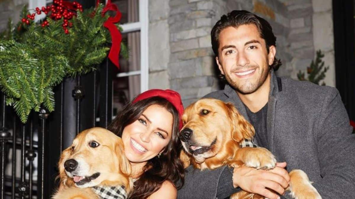 Kaitlyn Bristowe and Jason Tartick with their golden retriever dogs on a porch at Christmas