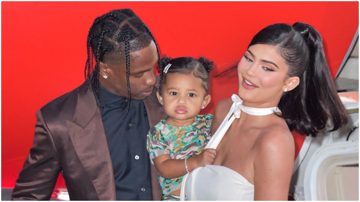 Travis Scott and Kylie Jenner holding Stormi Webster at an event.