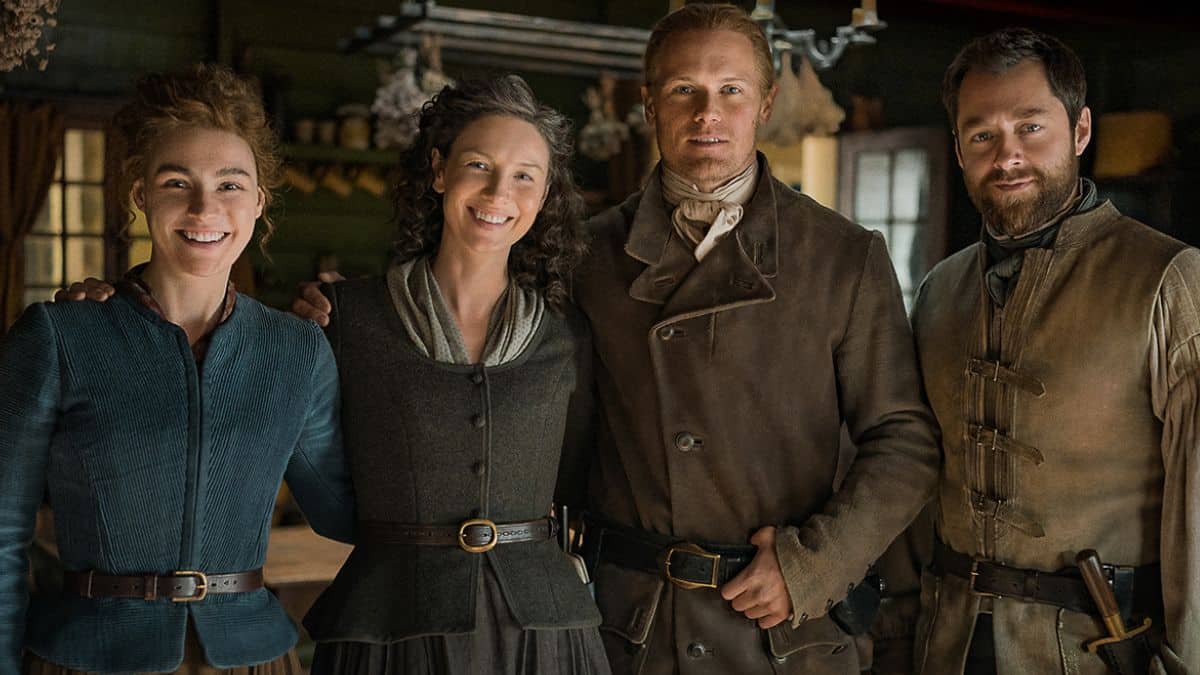 Sophie Skelton as Brianna, Caitriona Balfe as Claire, Sam Heughan as Jamie, and Richard Rankin as Roger, as seen in a promotional still for Season 7 of Starz's Outlander