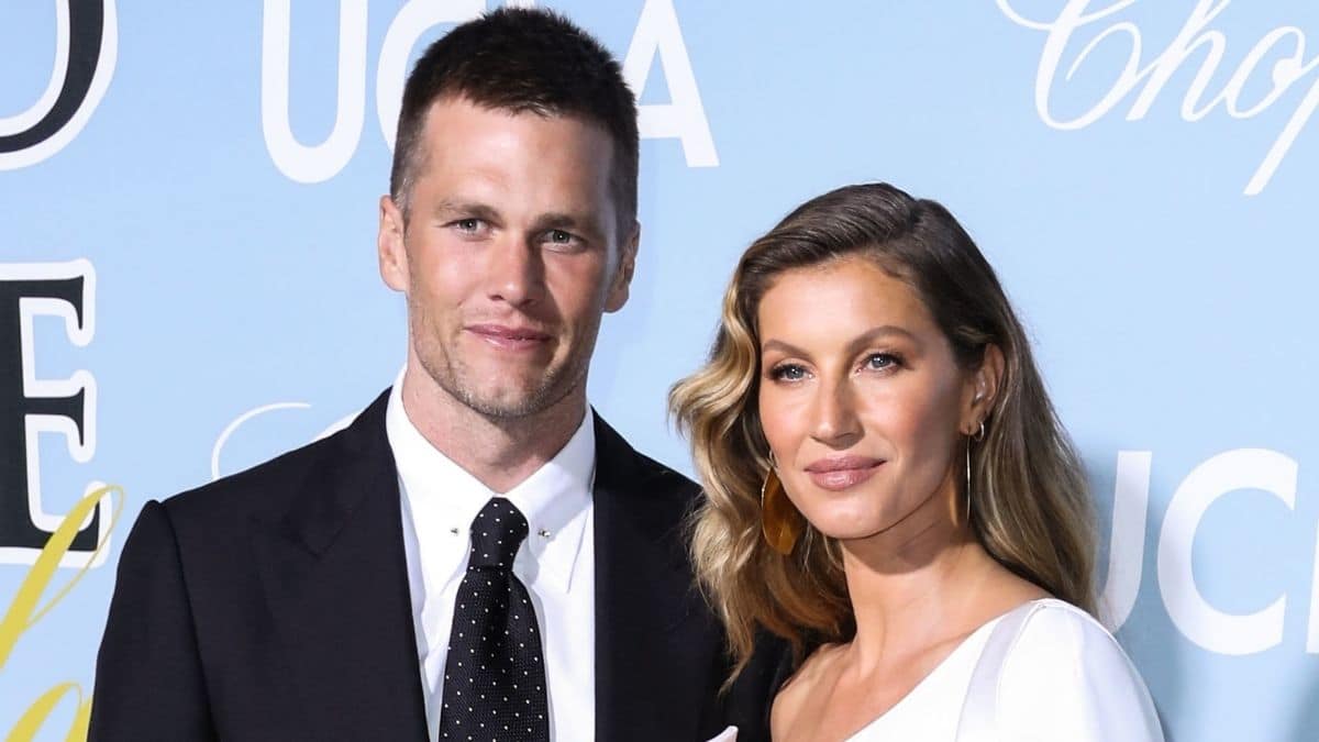 Tom Brady in a suit and wife Gisele Bundchen in a white dress at an event