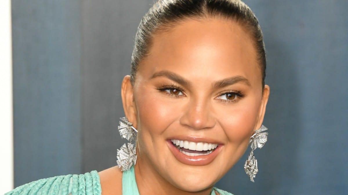Chrissy Teigen presents rear view in pink ballerina outfit