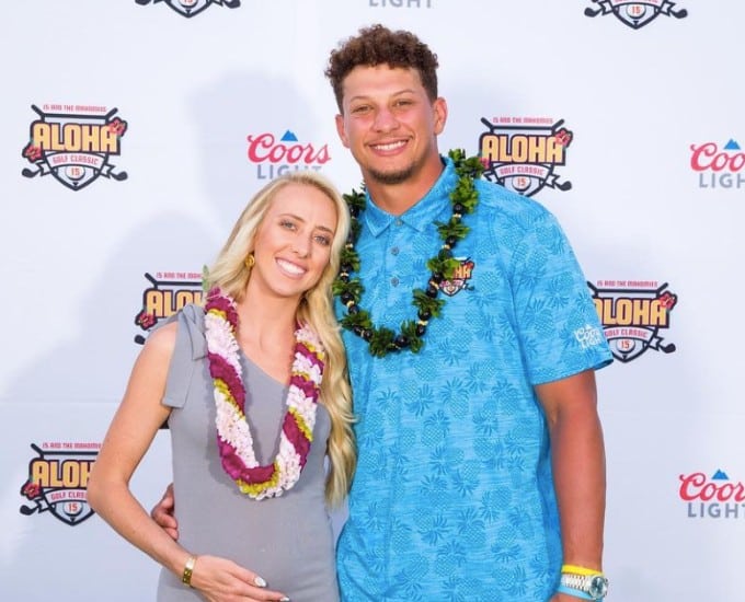 Patrick and Brittany Mahomes pose at the Aloha Golf Classic event, Brittany seen cradling baby bump