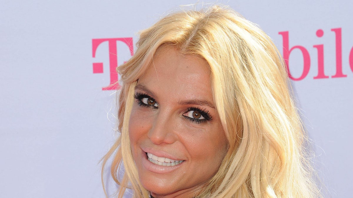 Britney Spears in sizzling crimson bikini holds child