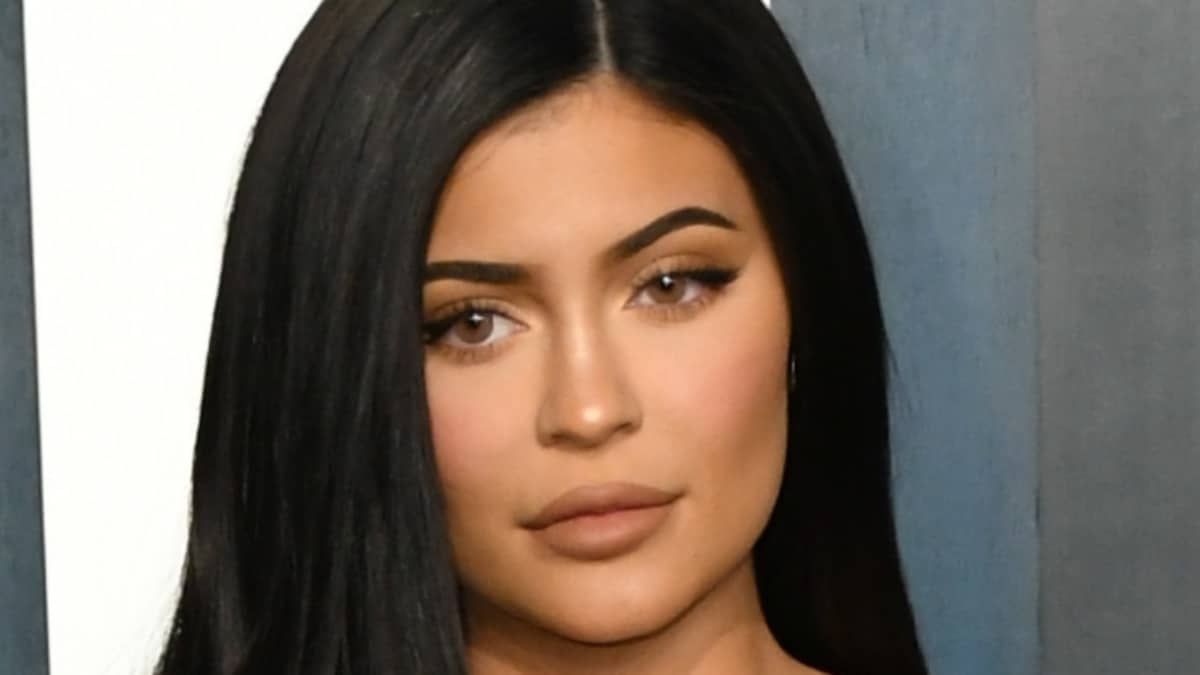 Kylie Jenner braless and sprawled throughout her mattress in a nightie