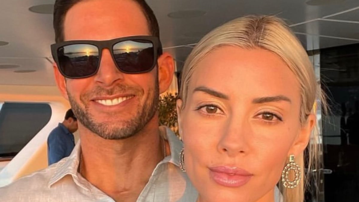 Heather Rae El Moussa and Tarek El Moussa smiling at the camera while on a boat.