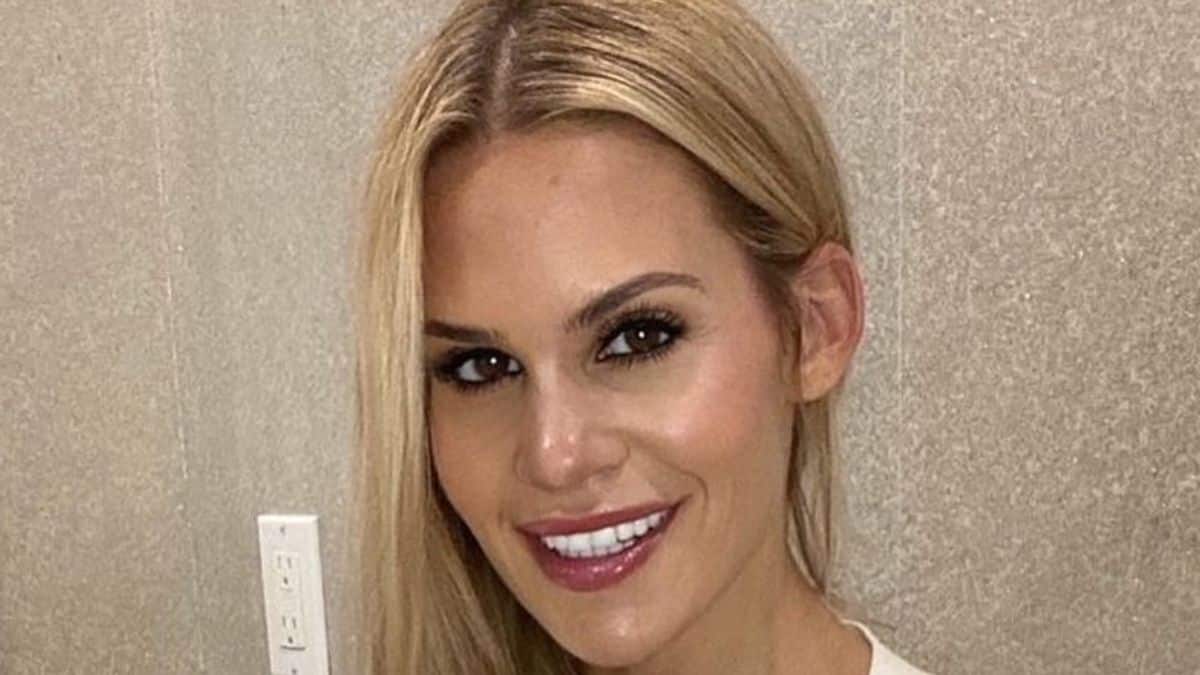 RHONJ star Jackie Goldschneider sports high-waist jeans and belly-baring top during football game.