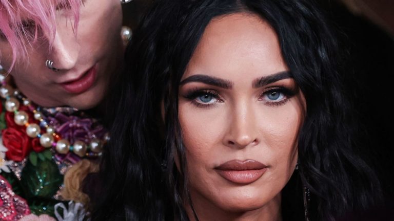 Megan Fox close up as Machine Gun Kelly embraces her from behind