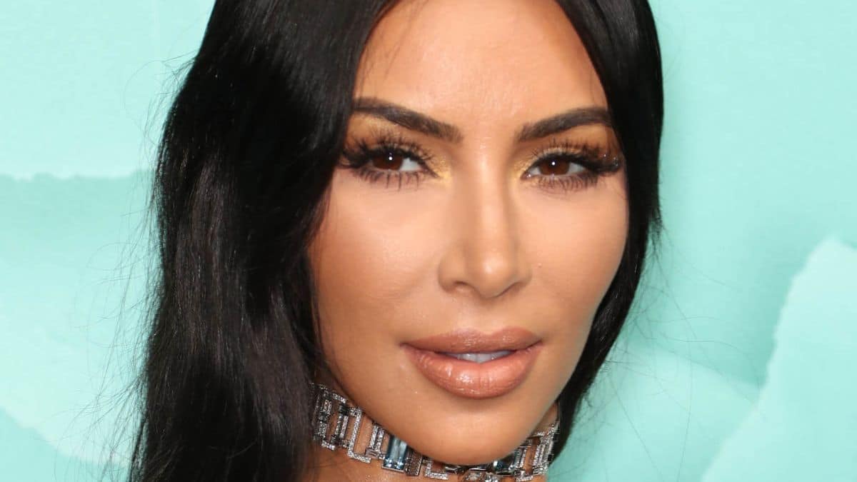 Kim Kardashian in front of a blue backdrop.